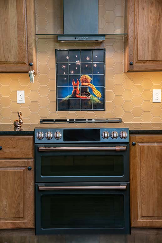 Illustrative tiled stovetop backsplash with girl and dog sitting on grassy hill looking at stars