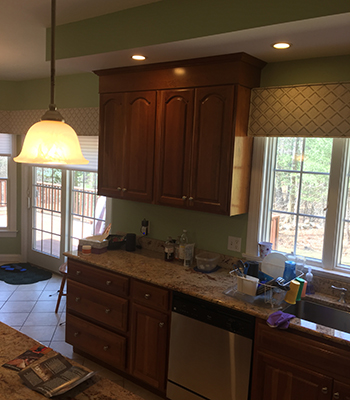 Traditional looking kitchen with light brown cabinets and green walls