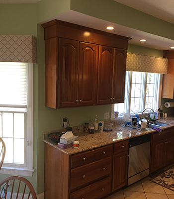 Kitchen with dark brown cabinets and green walls