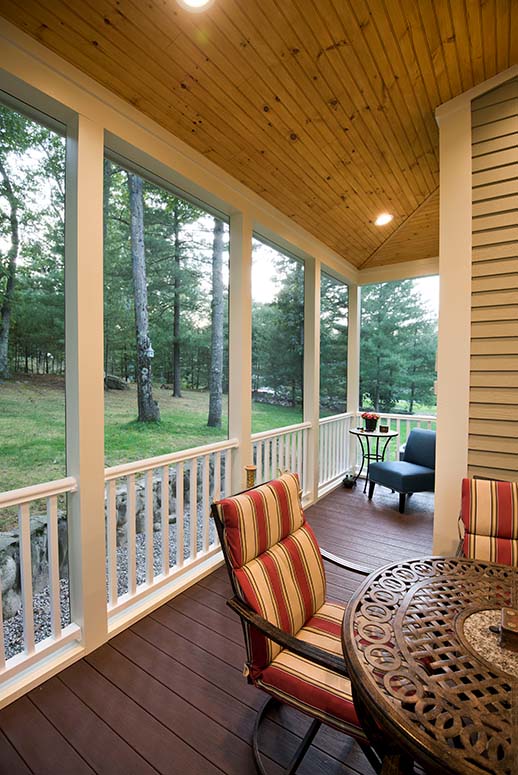Outdoor porch with outdoor chairs that is screened in