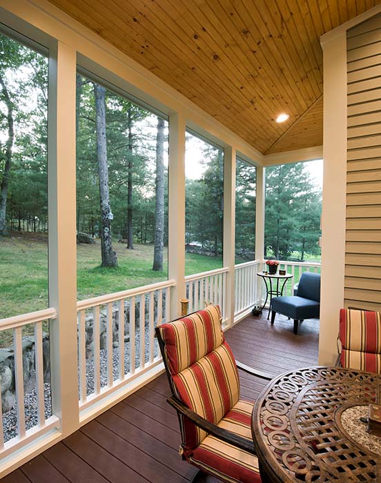 Outdoor porch with outdoor chairs that is screened in