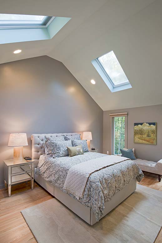 Cathedral grey bedroom with two skylights and tall windows