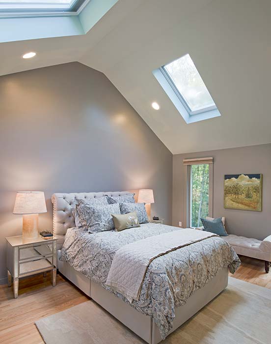 Cathedral grey bedroom with two skylights and tall windows