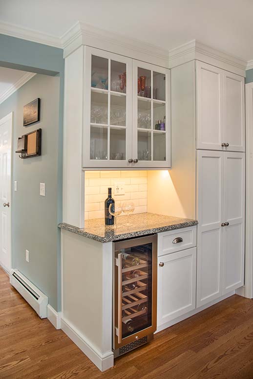 Kitchen wine bar with glass-faced cabinets and built-in wine fridge