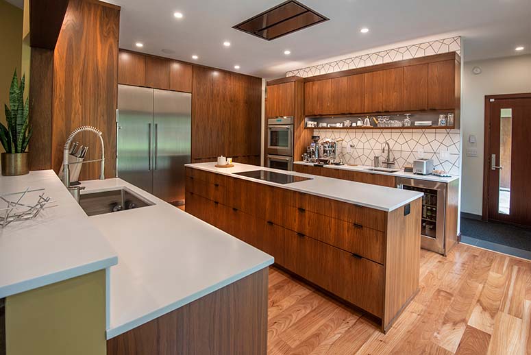 Modern kitchen with geometric backsplash and wooden island & floor-to-ceiling cabinetry