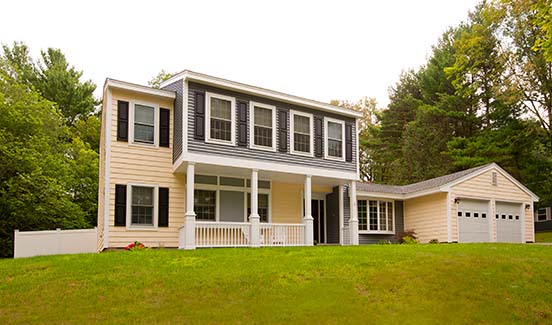 Updated two-toned yellow and dark grey siding on colonial-style house