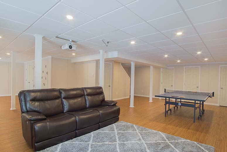 Renovated open plan basement with leather couch and ping pong table