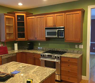Traditional looking kitchen with light brown cabinets and green walls