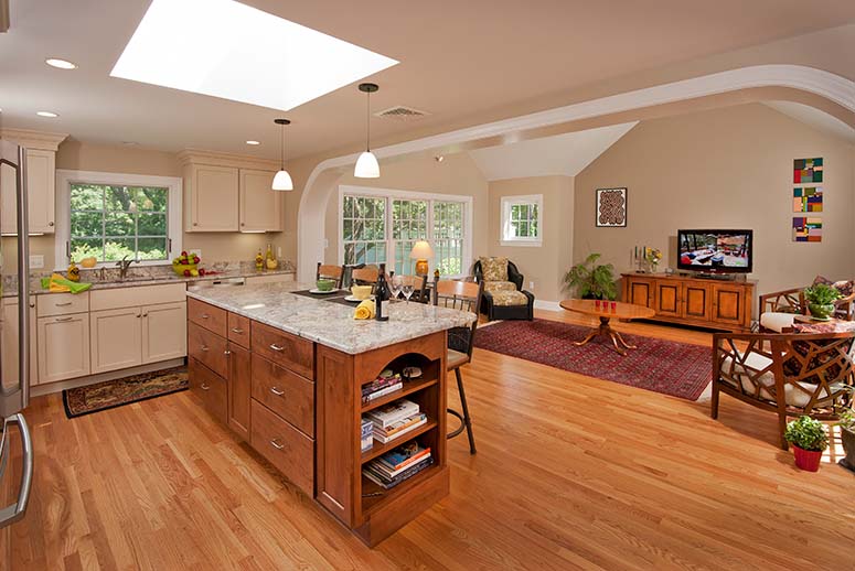 Kitchen with granite counters, white cabinets, and barstool chairs