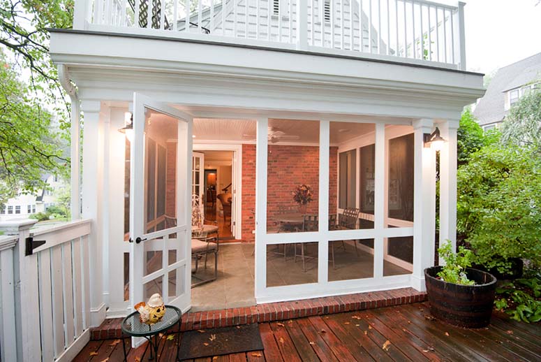White four seasons/screened porch addition leading onto back deck
