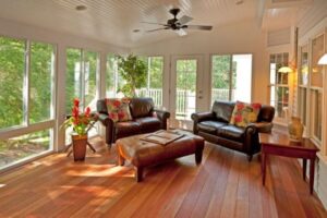 Sunroom with floor-to-ceiling windows and leather furniture