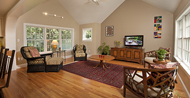 Living room with chairs, rug, coffee table and tv console
