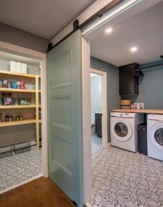 Updated walk-in pantry and laundry room with patterned tile floor and robin egg blue barn door