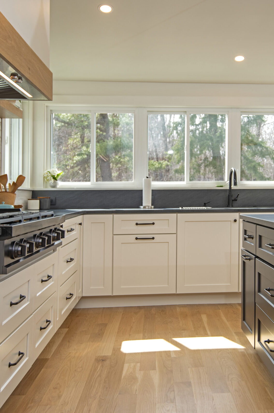 A custom designed kitchen with panroamic windows in front of the sink.